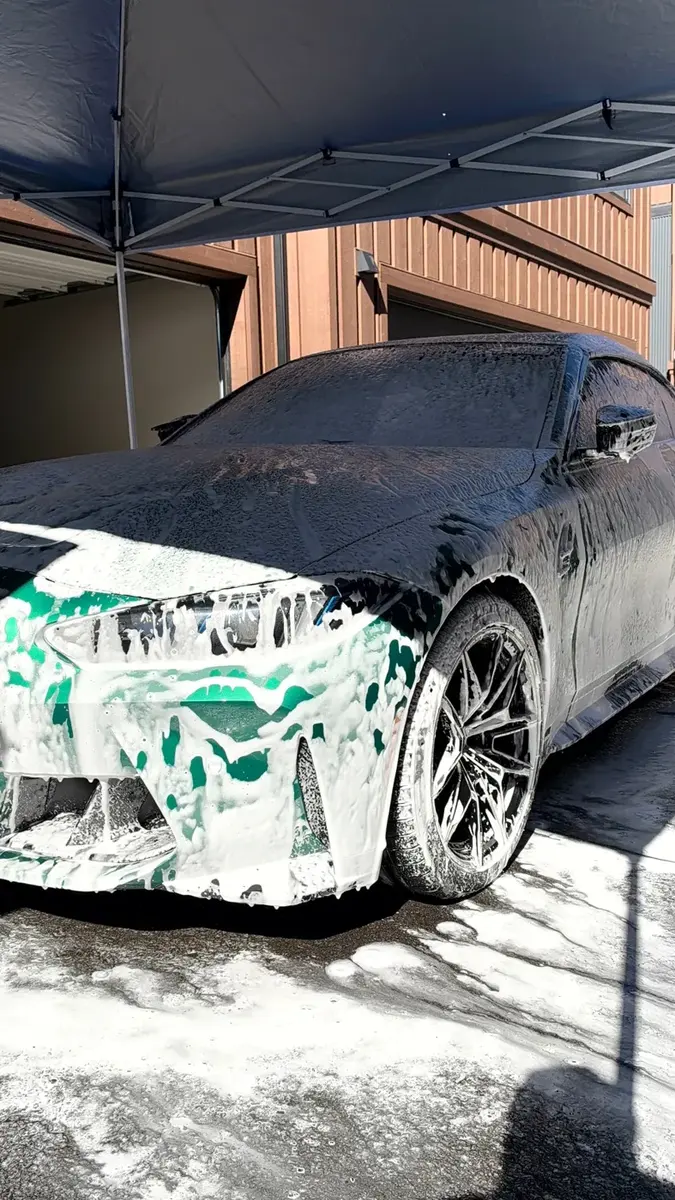 BMW M4 cubierto de espuma durante un lavado a mano de Cosmic